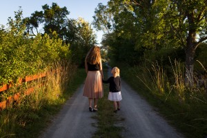 A mom walking with her daughter in a garden